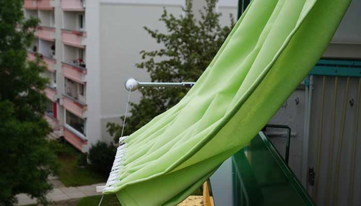 Nahaufnahme eines Seilspannsonnensegels auf dem Balkon